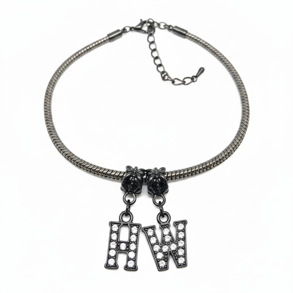 A silver-toned snake chain necklace with two hanging letter charms, one reading 'H' and one reading 'W', both adorned with clear rhinestones, shown on a plain white background.