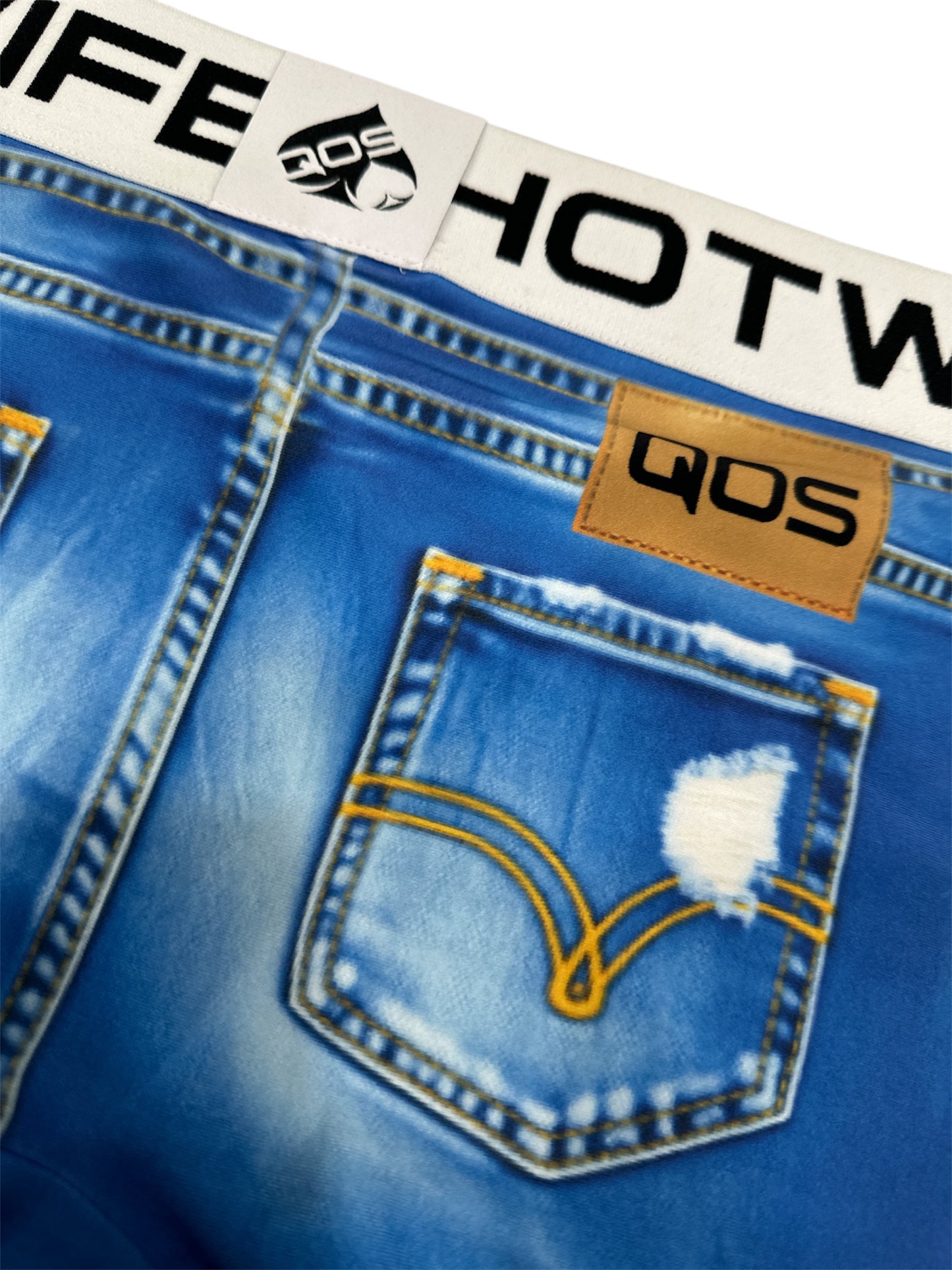 Close-up of blue jeans with a brand label on a white background