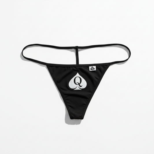 Black g-string bikini bottom with a large silver playing card spade logo on the front and a small brand tag on the right side, shown against a plain white background.