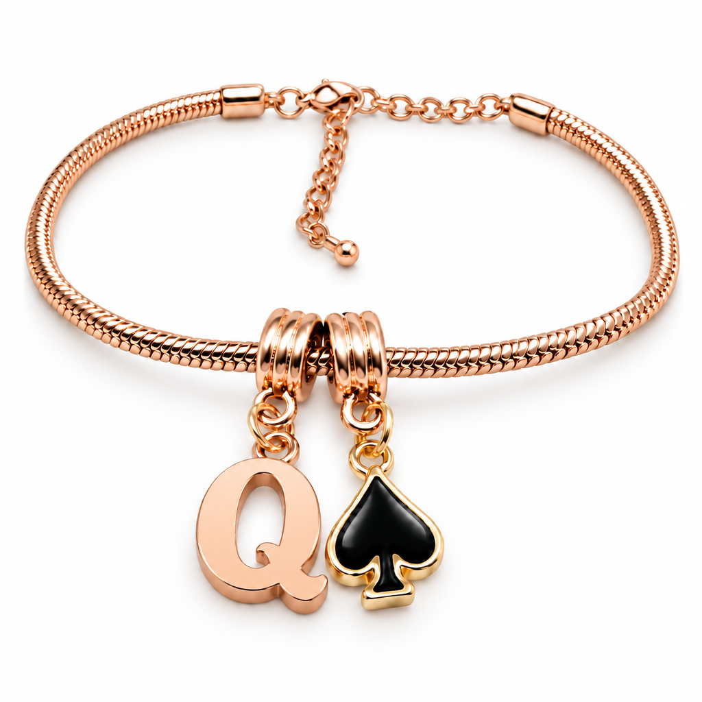 A rose gold snake chain bracelet with two charms: a gold-tone letter 'Q' charm and a gold-tone spade card charm with a black enamel center, shown on a white background.