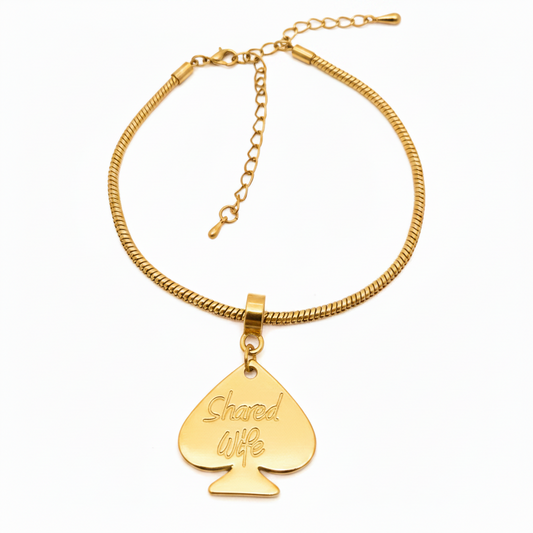 A dark gunmetal gray metal necklace featuring a snake chain and a teardrop-shaped pendant engraved with the words 'Shared Wife'.